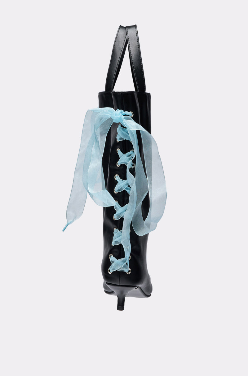 The TIE MY SHOE PURSE is a black purse styled like a heeled boot with pointed toe and sheer light blue ribbon laces crisscrossed on the front, finished with a large bow—an elegant, stand-out addition to any wardrobe. 3