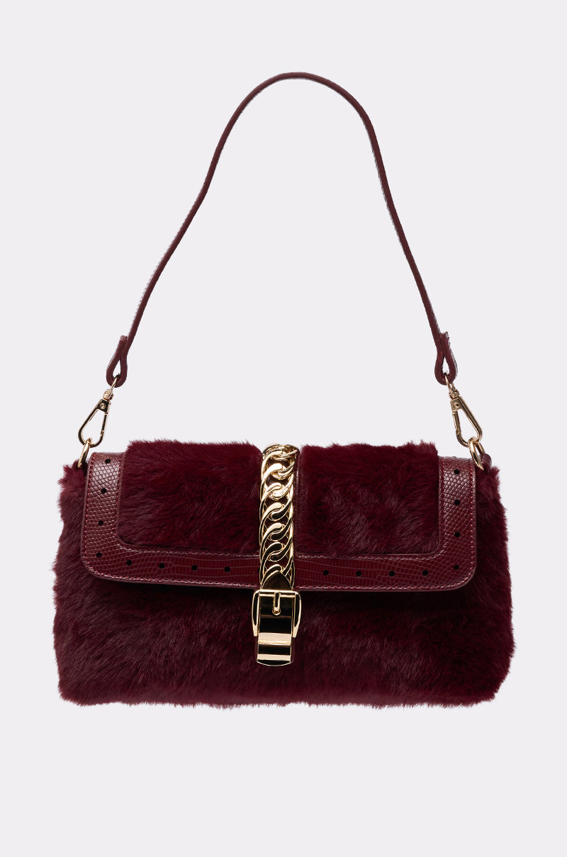 The LOUIS FAUX FUR PURSE is a burgundy bag with a gold-tone chain lock, croc-embossed faux leather strap, and a flap closure.