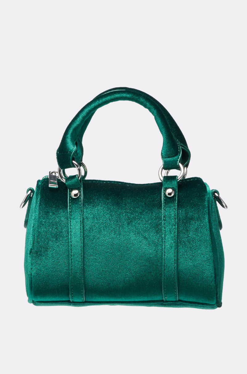 The JESSI VELVET PURSE is a small, structured green velvet bag with two short handles and silver hardware, shown against a plain light gray background. 0