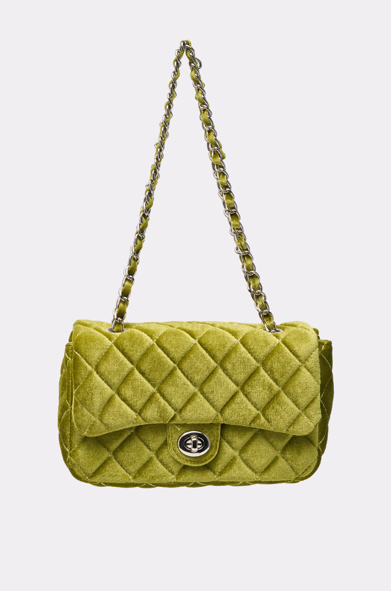 The NIKKI VELVET QUILTED PURSE in chartreuse features a gold chain strap and a silver turn-lock clasp, shown against a plain white background. 0