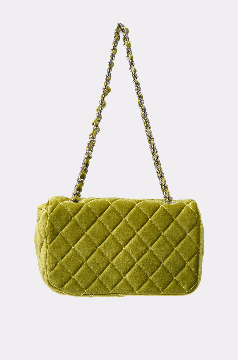The NIKKI VELVET QUILTED PURSE, featuring a chartreuse hue, quilted design, and gold chain strap, is displayed against a plain white background. 3