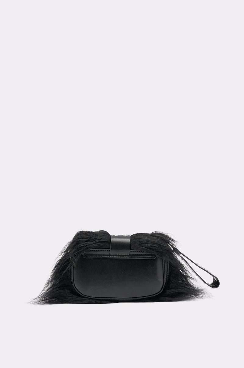 The ON THE TOWN WRISTLET is a small black clutch with long faux fur trim on top, a smooth faux leather body, and a wrist strap, shown against a light gray background—an elegant accessory for nights out. 3