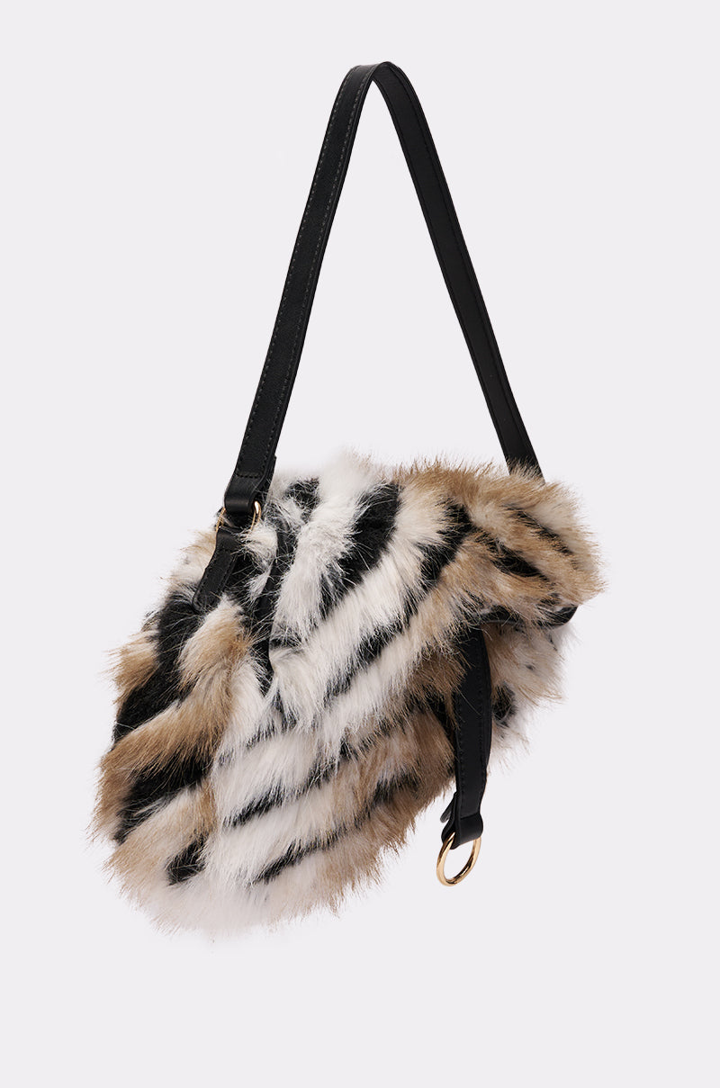 The SOFIA FAUX FUR BAG is a small saddle bag with a black strap and a fluffy faux fur body, featuring black, white, and brown chevron stripes. It’s shown against a plain light background. 2