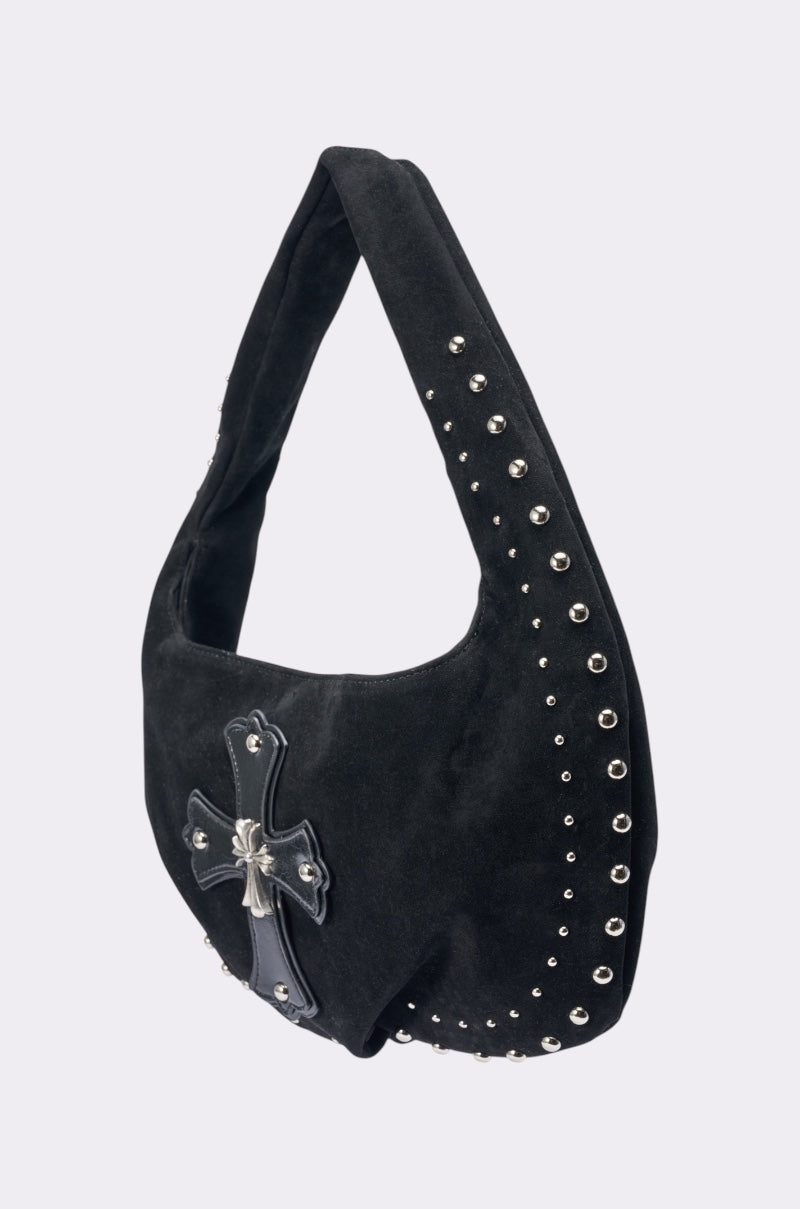 The REALLY THAT GIRL SUEDE BAG is a black faux suede shoulder bag with silver studs and a large leather cross with a silver emblem on the front—perfect for adding bold style to any outfit. 2