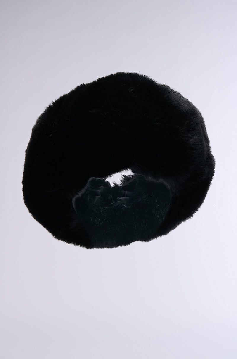 The LUXE JENNY FAUX FUR HEADBAND IN BLACK features a circular design, ideal as a winter ear cover, shown against a plain light gray background.