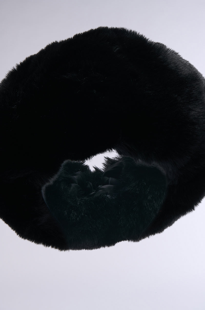 A close-up of the LUXE JENNY FAUX FUR HEADBAND IN BLACK, arranged in a loop against a plain light background, showcases its plush, circular design—perfect as a cozy winter accessory.