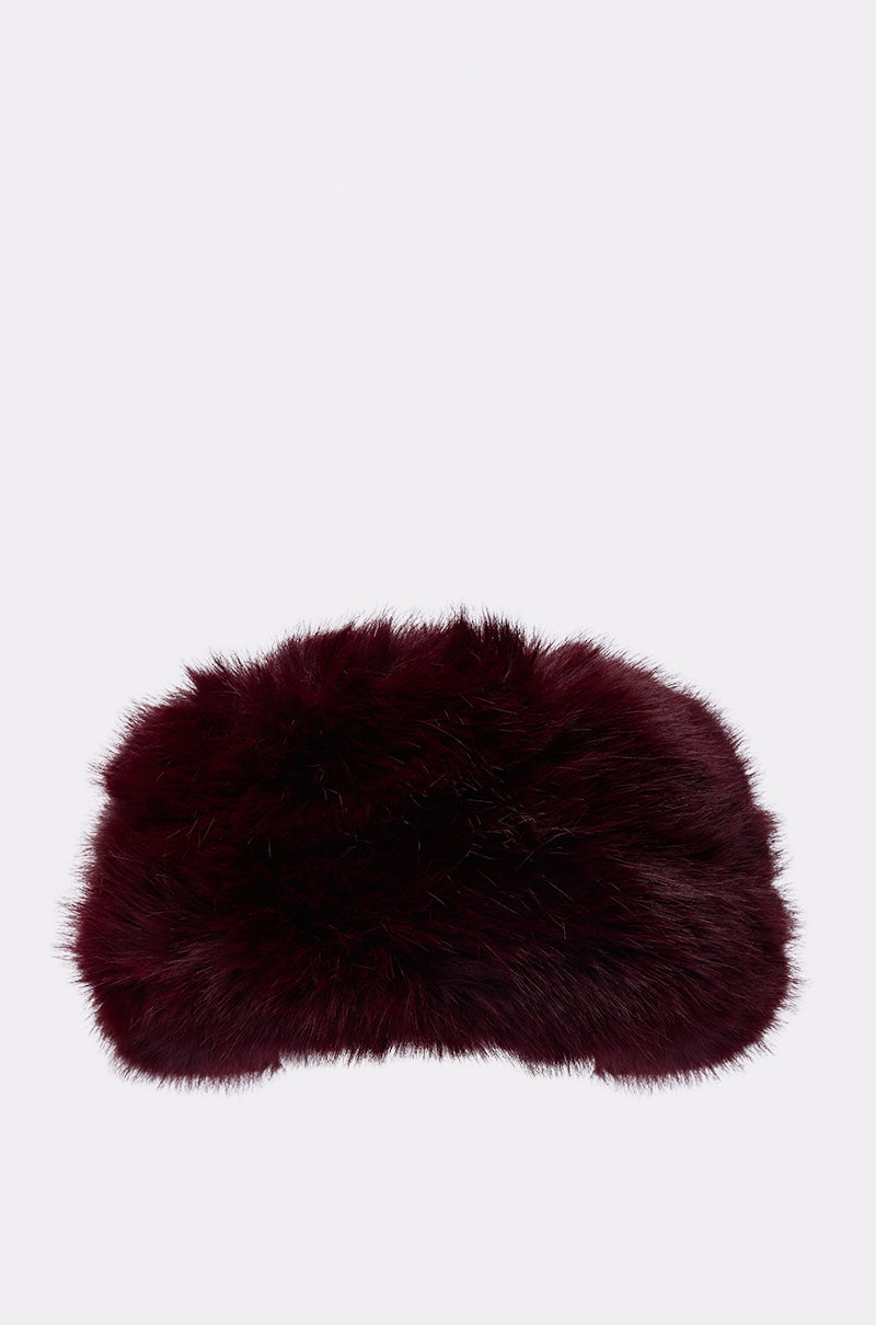 The ALAIA FAUX FUR HEADBAND, a fluffy dark burgundy accessory with a rounded shape, is displayed against a plain white background—ideal for adding chic style in cold weather.