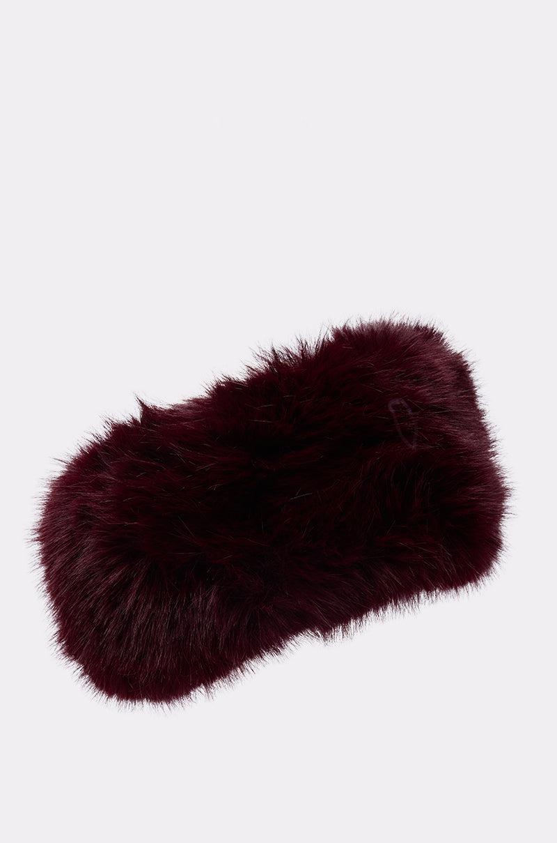 The ALAIA FAUX FUR HEADBAND, a plush dark burgundy accessory, is displayed against a plain white background, highlighting its cozy winter style.