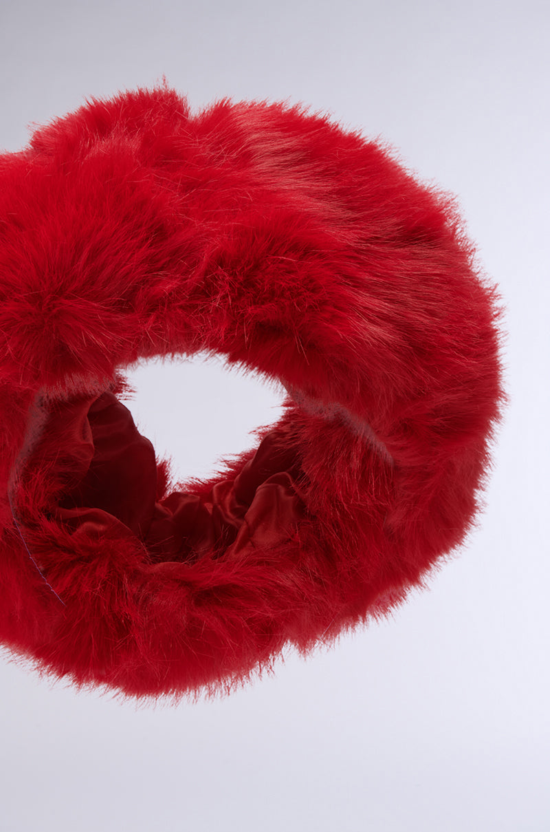 The LOOK AT ME NOW FAUX FUR HEADBAND, featuring a circular design in red with a fluffy faux fur texture, sits against a plain white background. 4