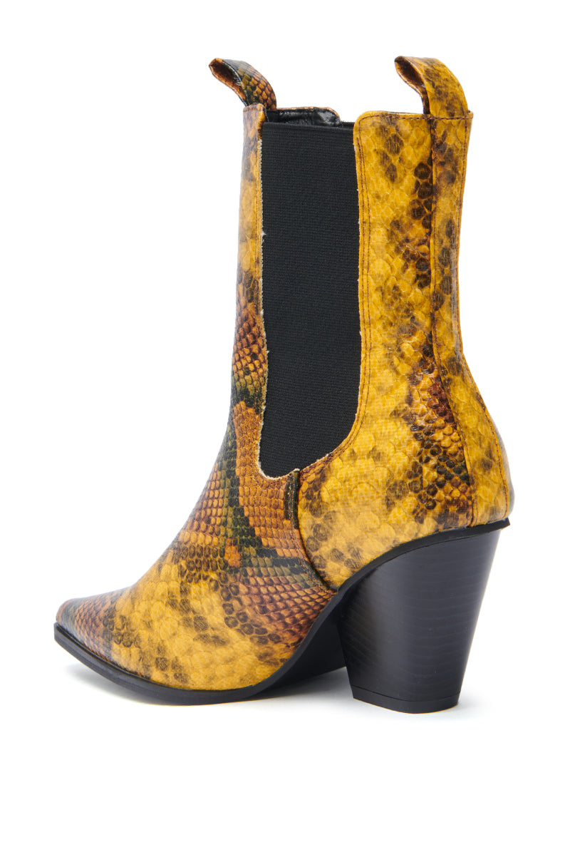 The AZALEA WANG HENDERSON YELLOW CHUNKY BOOTIE features a yellow and brown faux snakeskin design, black elastic side panels, pull tabs, and a chunky black angled heel.