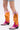 A person in light denim shorts stands on a white background wearing the AZALEA WANG SPICE IT UP CHUNKY BOOT IN MULTI—metallic pink and orange cowboy boots featuring decorative patterns and a chunky heel.