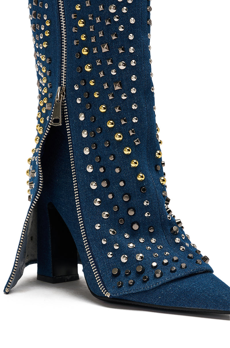 A close-up of the AZALEA WANG HENZI DENIM STUDDED CHUNKY BOOTIE—a blue mid-calf denim boot with silver, gold, and black studs, a bold side silver zipper, and a pointed toe for standout style. 8