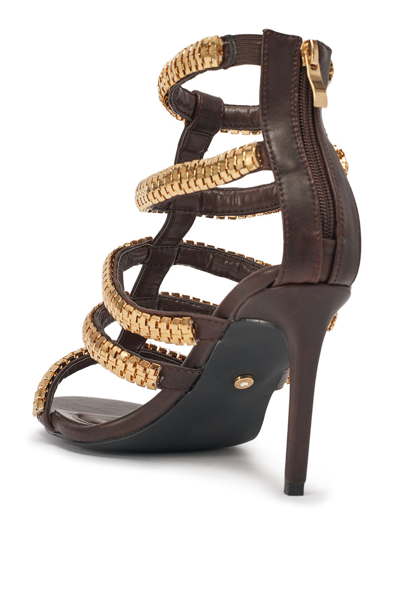 The AZALEA WANG HERSILIE BROWN GLADIATOR STILETTO features dark brown faux leather, gold chain straps, an ankle-high design, back zipper closure, and a thin stiletto heel for a bold gladiator-inspired style. 7