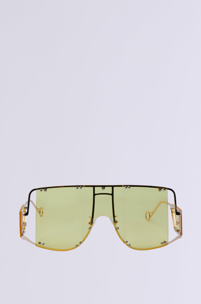 The BOUJEE BISH SUNGLASSES feature yellow-tinted lenses and an oversized rectangular frame with black accents. The bold design is complemented by unique transparent temples, making them ideal for a contemporary statement.