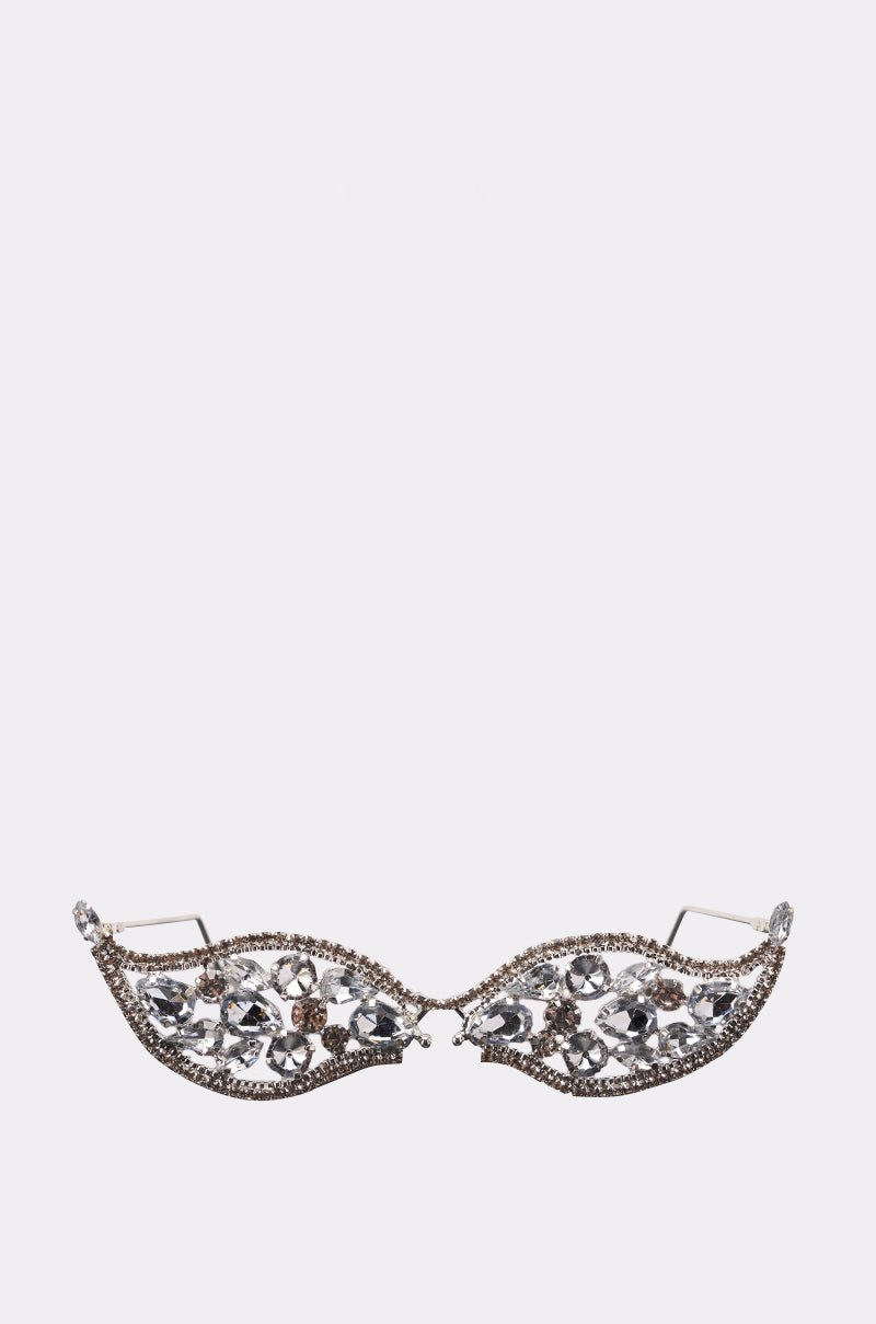 The HERE FOR THE DRAMA BLING GLASSES from AKIRA Label feature rhinestone embellishments with sparkling accents and intricate filigree designs, displayed against a plain white background.