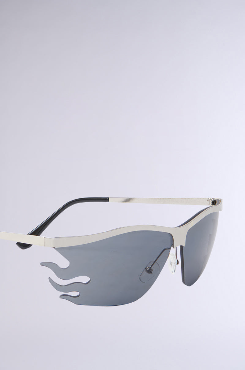 The FEEL THE FLAME SUNGLASSES feature a sleek metal frame with rectangular tinted lenses, dark shades, adjustable nose pads, all set against a plain gray background.