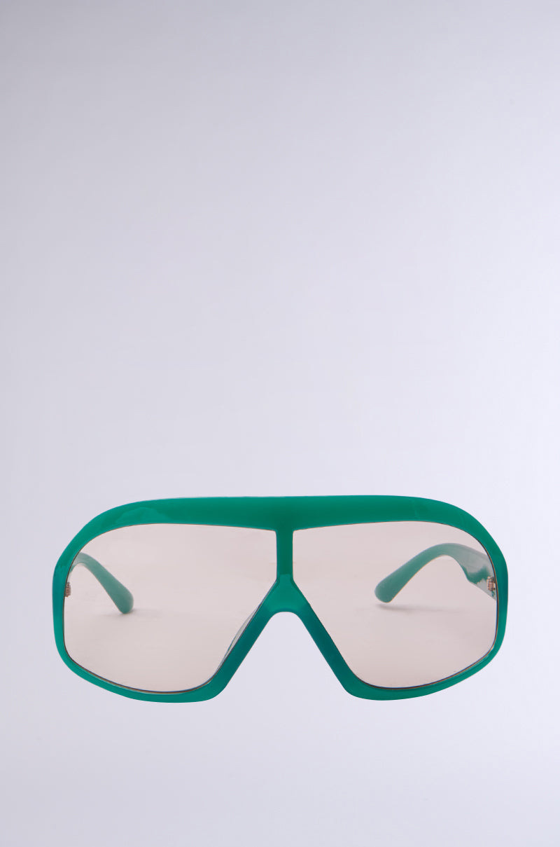 The ALYSSA Sunglasses, featuring oversized green lenses with a retro design and thick frame, offer a stylish aviator look with a single continuous lens against a neutral light gray background. 2