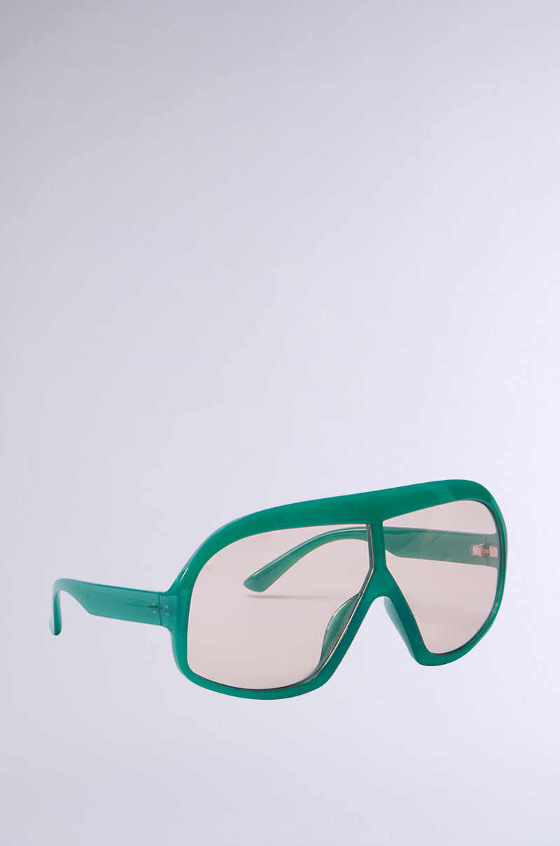 The ALYSSA Sunglasses have a unique wrap-around design with oversized, slightly tinted lenses and an aviator-style look. The large green plastic frames are glossy, contrasting with a plain light grey background. 0