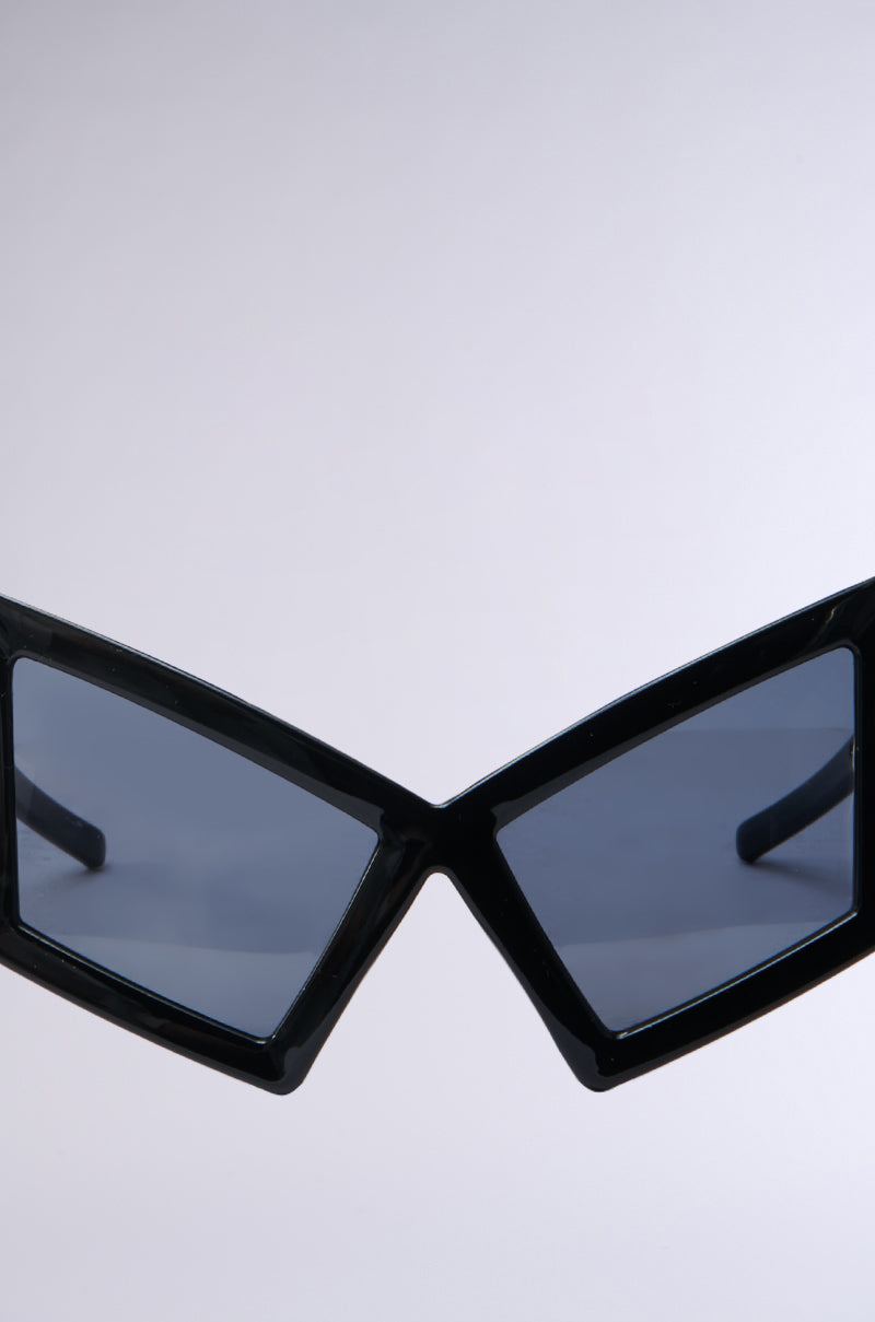 U HAVE TO GET IT SUNGLASSES featuring black geometric frames, tinted lenses, and oversized temple arms on a light backdrop for a Matrix-chic style.