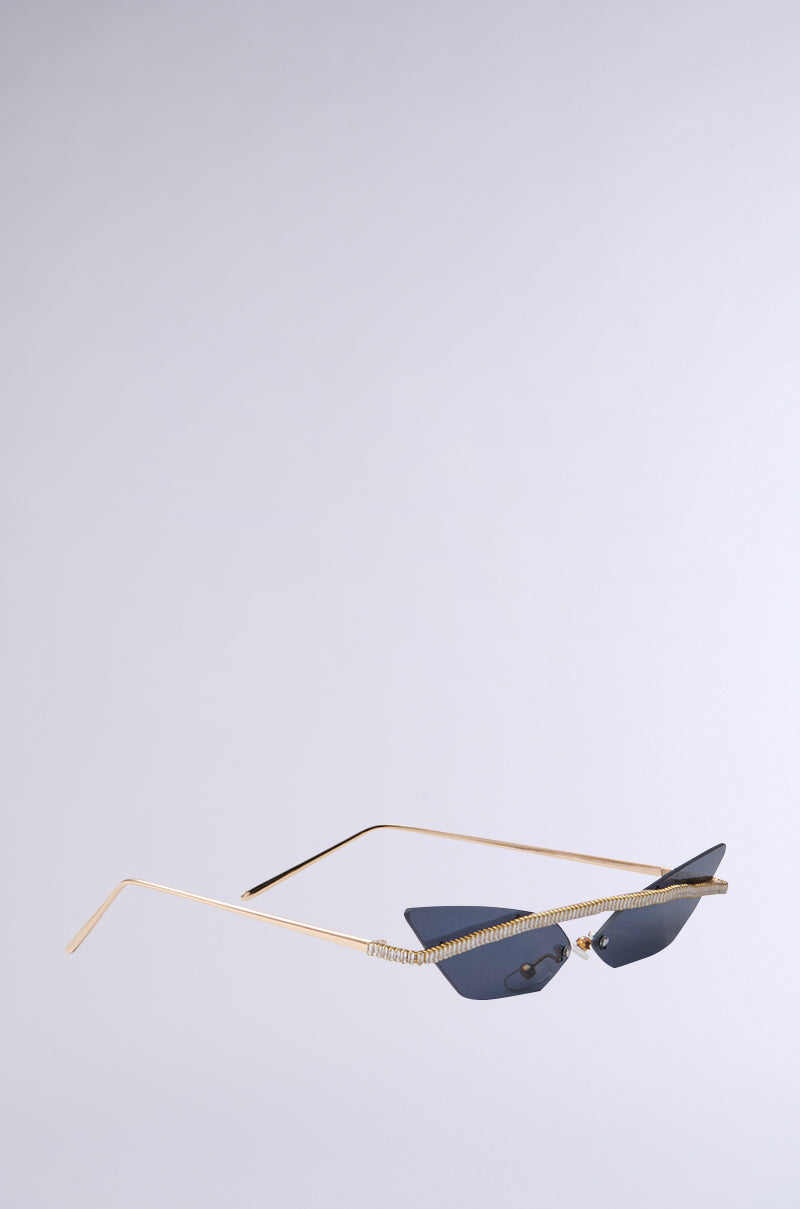 The GET ALIGNED SUNGLASSES showcase a sleek cat eye design with narrow black lenses, gold wireframe arms, and rhinestone embellishments on the top edge, all highlighted against a plain white background. 4