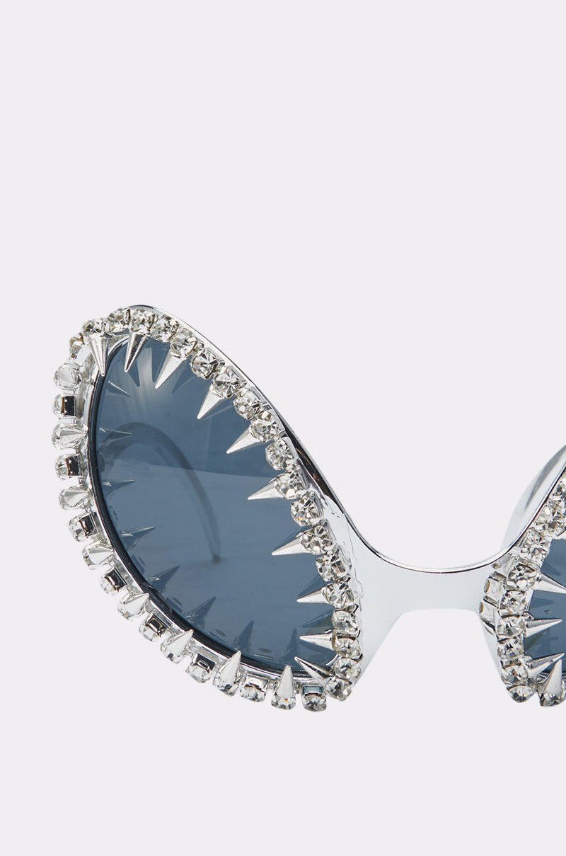Close-up of BUGGIN BLING SUNGLASSES featuring dark lenses, a silver frame decorated with clear rhinestones and metallic spikes for an oversized bug-eye look. 4
