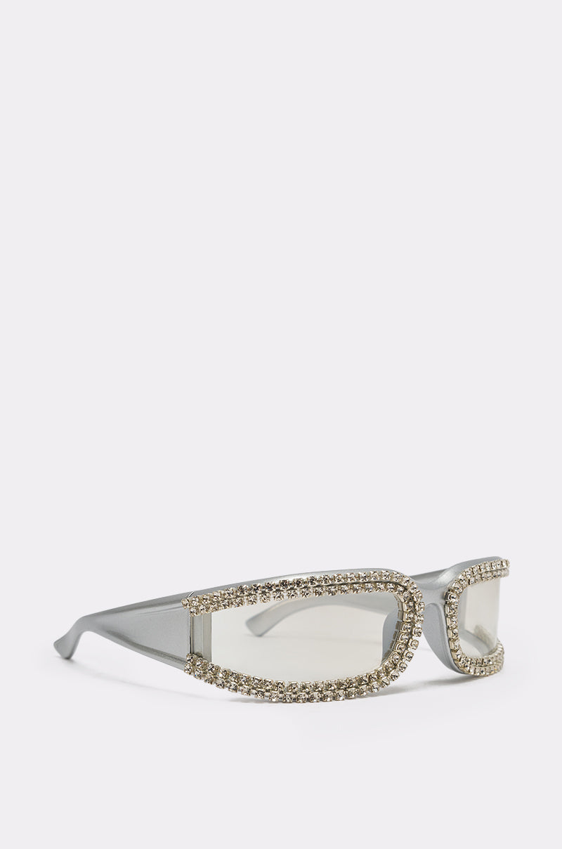 NIKKI SUNGLASSES feature thick silver shield frames with two rows of dazzling rhinestones outlining the front for a bold, festival-ready style. Shown against a plain white background. 3