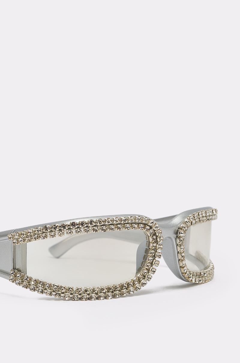 NIKKI SUNGLASSES: Silver rectangular festival sunglasses with clear lenses, featuring a thick frame adorned with multiple rows of sparkling rhinestones along the edges. 4