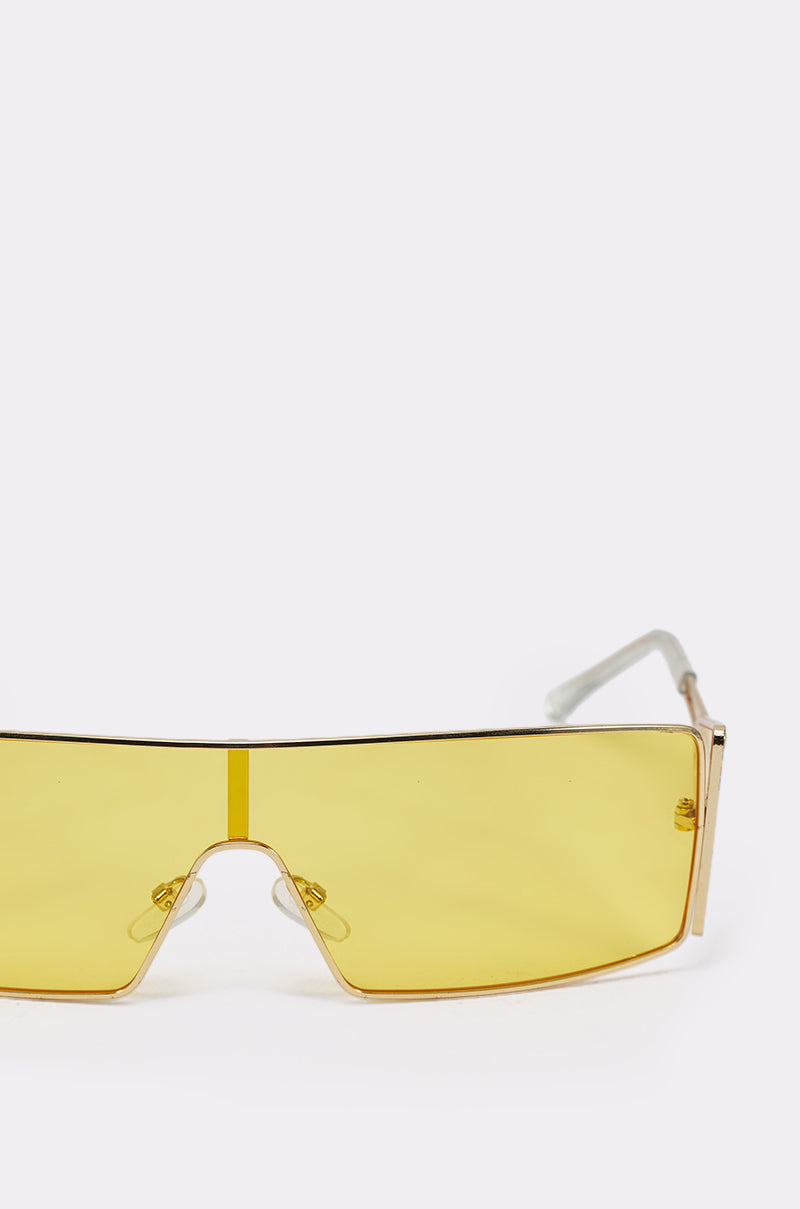 LEMON TWIST SUNGLASSES: Large, rectangular festival shades with yellow-tinted lenses and slim gold frames, displayed on a plain white background. 4