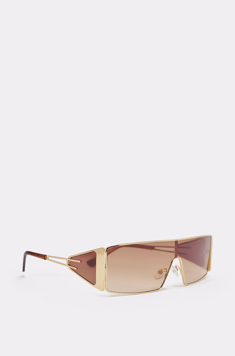 VIXEN SUNGLASSES featuring a gold-tone metal frame, geometric design, and gradient brown lenses with wide angular side panels, displayed on a plain white background. 3