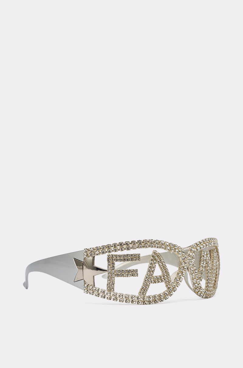 The FAME SUNGLASSES spell out "FAM" in sparkling rhinestones across oversized lenses. With a metallic finish and star accents, these bold festival sunglasses are perfect for making a statement. 3