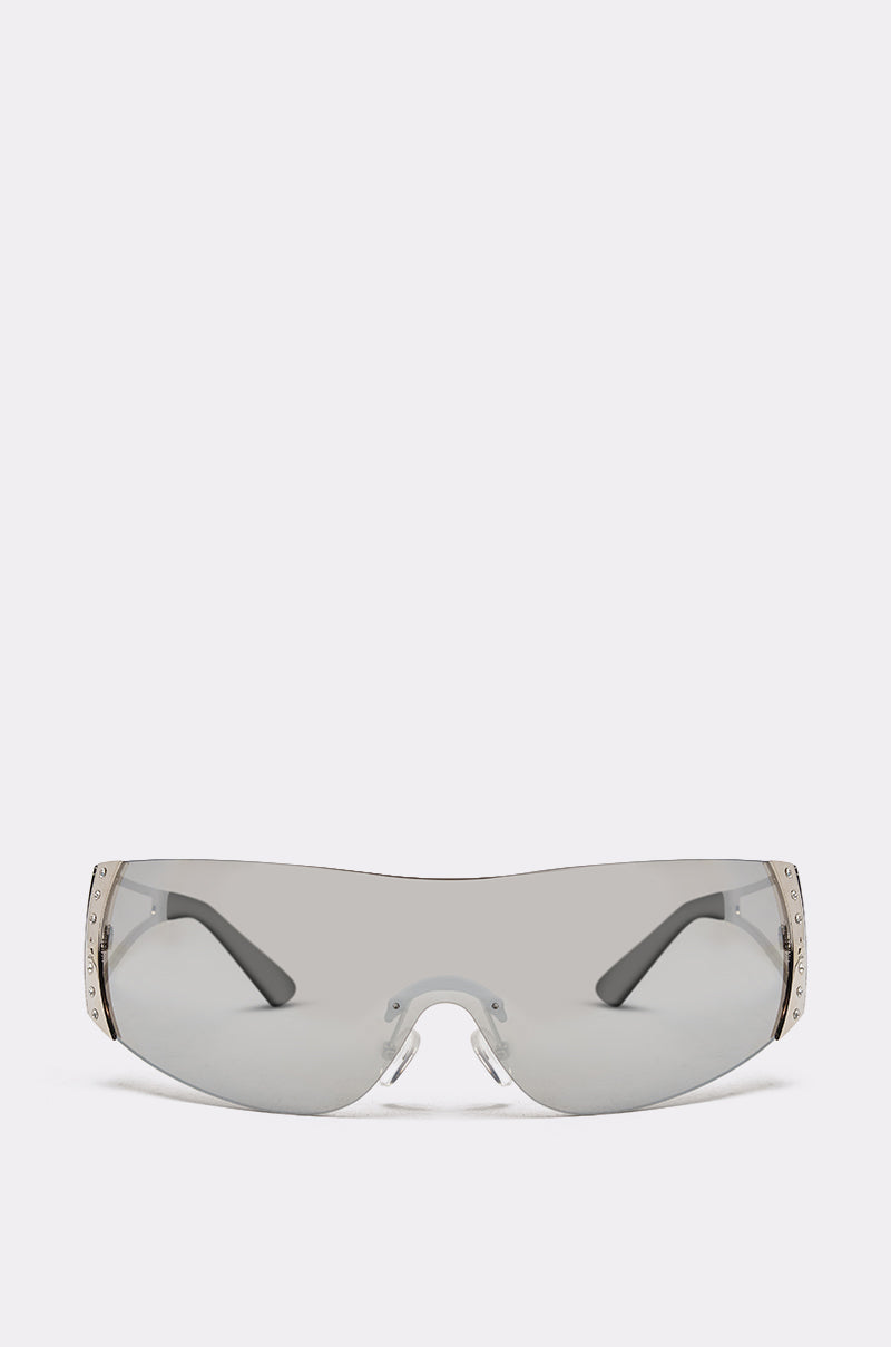 EVERY DAY SUNGLASSES: Sleek, futuristic wraparound sunglasses with a frameless design and metallic side detailing, shown against a plain light background. 3