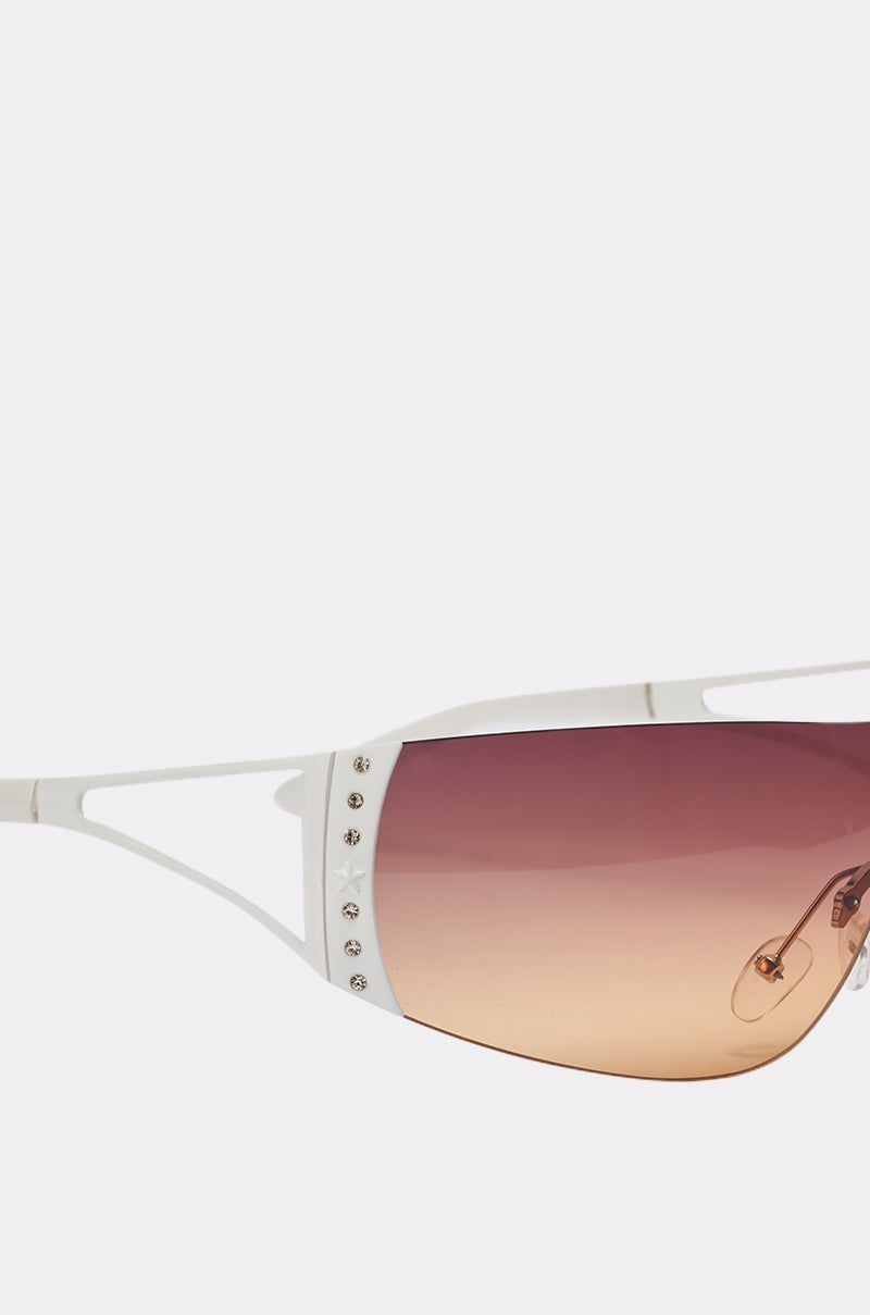 Close-up of NEUTRALEYES SUNGLASSES featuring a sleek white Y2K frame, brown gradient lenses, and decorative silver studs on the upper lens corners. 3