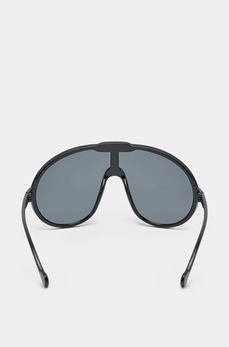 The BIGGER IS BETTER BLACK SUNGLASSES feature a shield design with dark tinted lenses, shown from the front on a light background, blending sporty fashion with classic aviator style. 3
