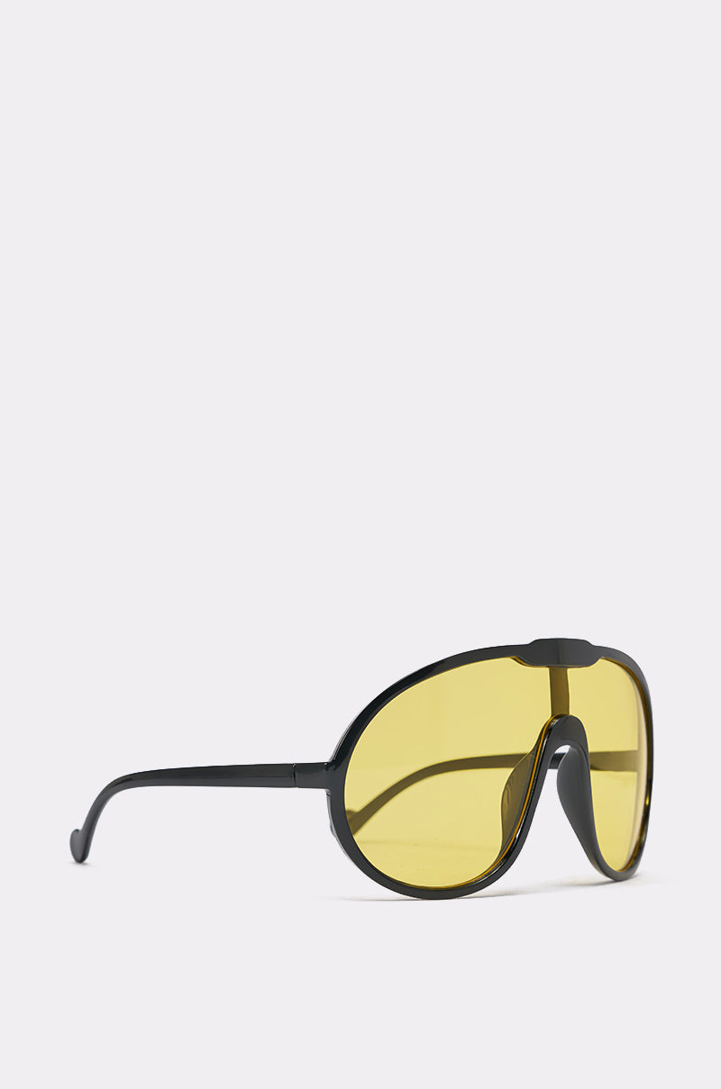 MOD SUNGLASSES feature oversized wraparound black frames and large curved yellow-tinted lenses, displayed against a light gray background. 3