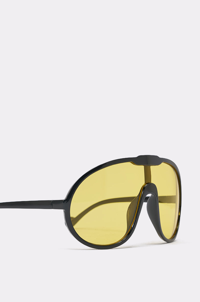 MOD SUNGLASSES feature oversized wraparound design with large, single-piece yellow-tinted lenses and a curved frame, displayed at an angle on a plain white background. 4