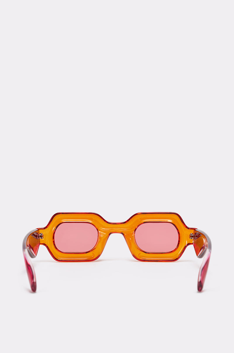 The SORBET SUNGLASSES feature chunky orange, geometric frames and rosy tinted lenses, showcased against a plain white background. 3