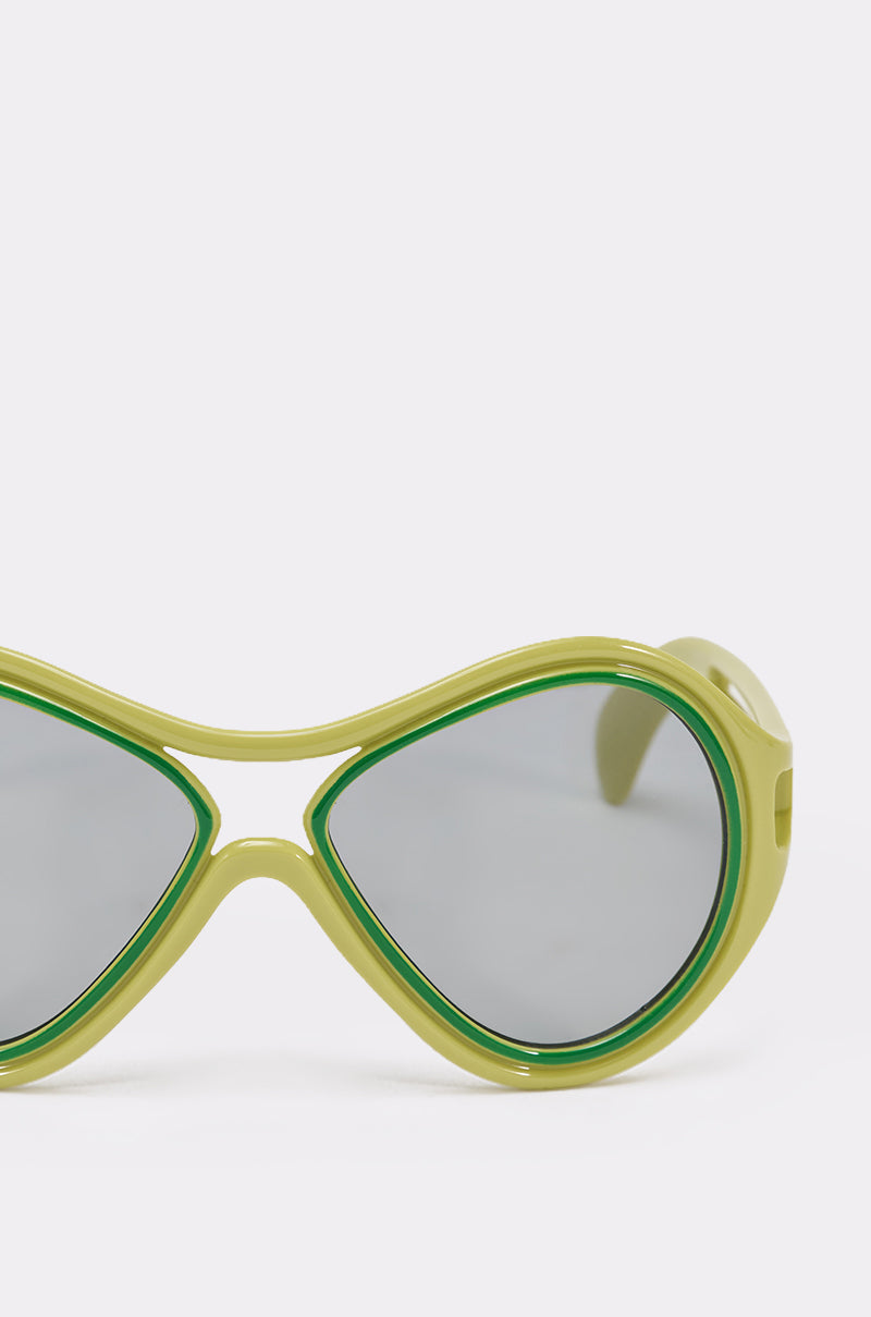 Close-up of the right side of IN MY WORLD SUNGLASSES featuring lime green thick frames, green trim, and gray-tinted lenses on a plain white background. 4
