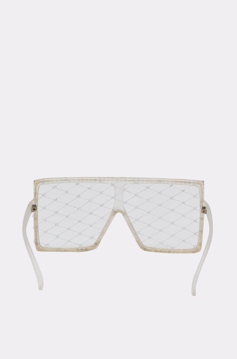BEEZ SUNGLASSES feature clear oversized shield lenses with a geometric crisscross pattern and transparent frames, displayed against a plain light gray background. 2
