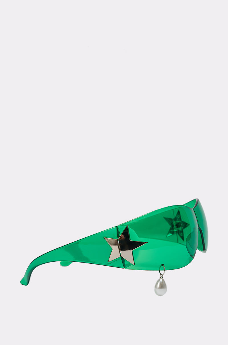 I DONT CRY SUNGLASSES: Visor-style, bright green shield sunglasses featuring a metallic star detail and a dangling pearl charm on one side, shown on a plain white background. 2