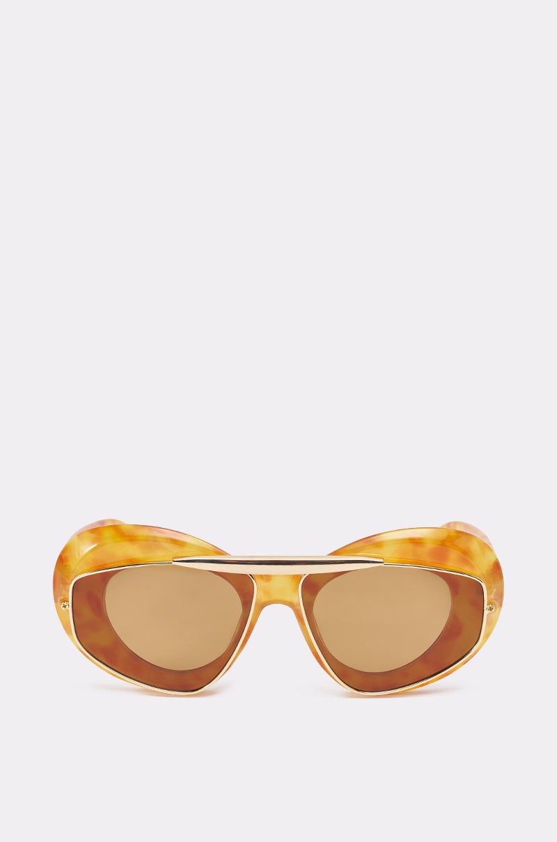 The QUITE LUX SUNGLASSES feature oversized tortoise shell frames, oval lenses, a gold-tone brow bar, and thick rounded edges for a retro vibe, shown against a plain white background. 1
