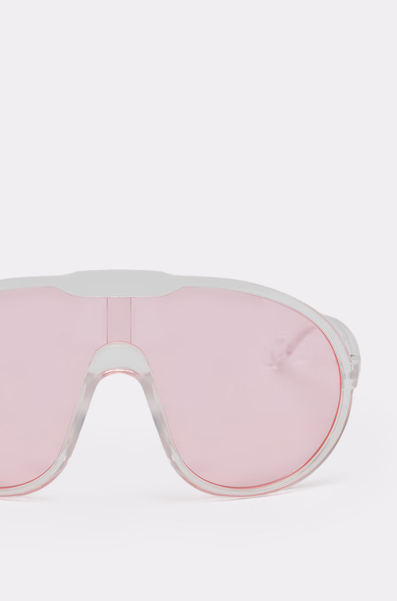 A close-up of PINK VISION SUNGLASSES shows large, pink-tinted lenses against a plain white background. Only the upper half of these stylish shield sunglasses is visible. 6