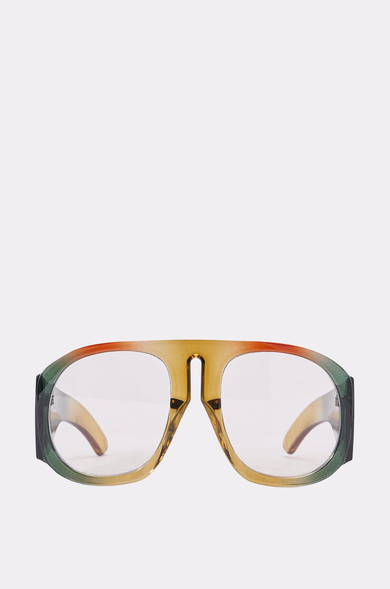 Make a bold statement with IT GIRL GLASSES—oversized, retro-style eyewear featuring clear lenses and a thick marbled green frame accented with yellow and orange, shown against a plain white background. 0