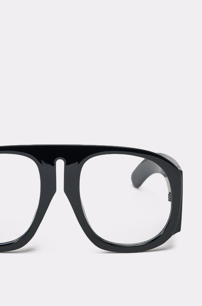 Close-up of the right half of READ ME GLASSES, featuring bold black frames and clear lenses, set against a plain light background. 4