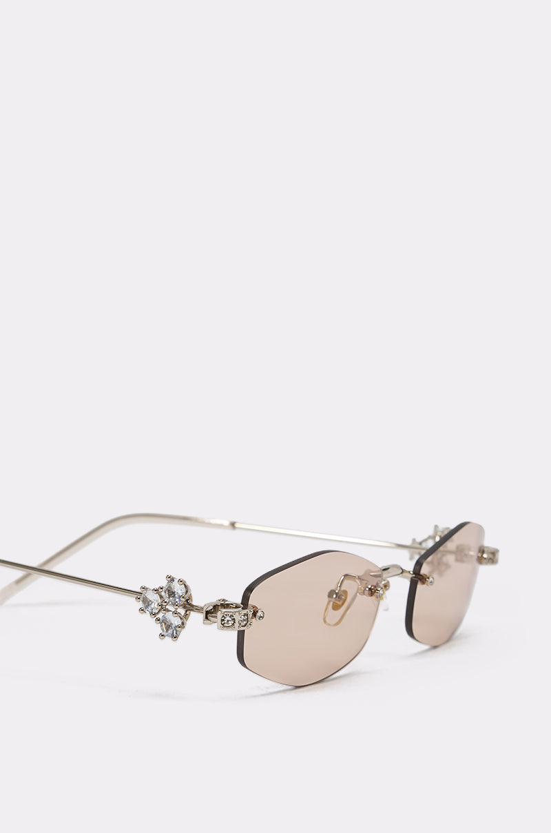 TRENDSTER GLASSES: Y2K oval sunglasses featuring light brown tinted lenses and decorative crystal embellishments on the temples, shown against a plain white background. 6