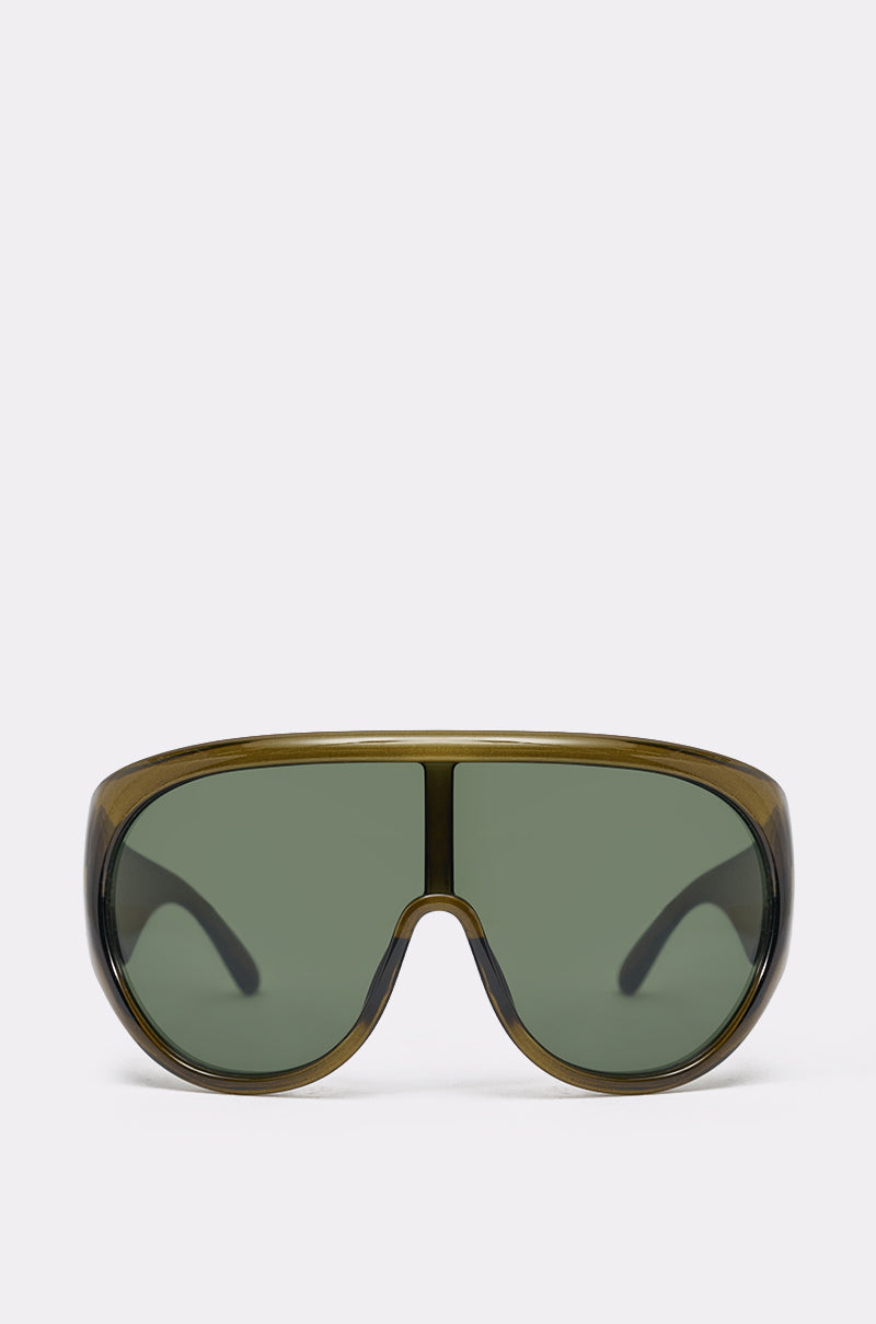 TOMBOY SUNGLASSES in olive green feature an oversized shield design with a single curved, dark-tinted lens and wide frame—ideal streetwear sunglasses. Shown against a plain light background. 1