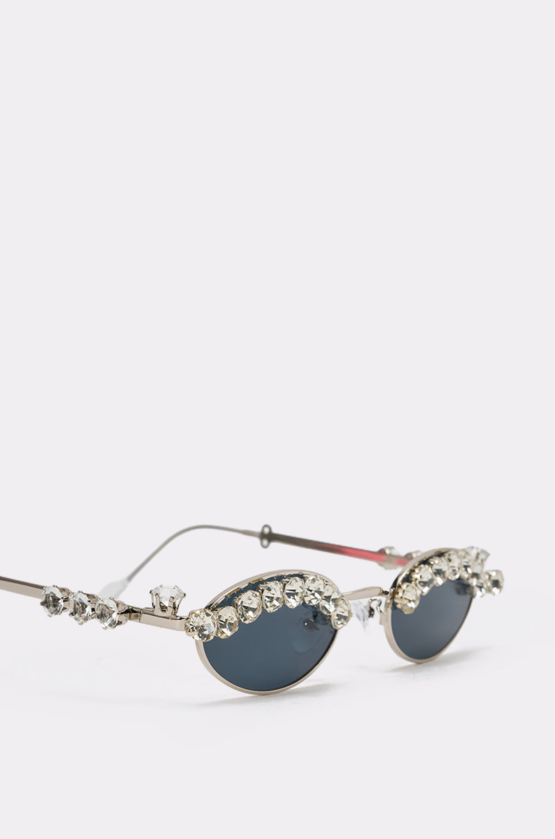 The CRY DIAMONDS SUNGLASSES are retro-style sunnies with dark lenses and large, decorative rhinestones on the top of the frames and arms, shown against a plain light background. 3