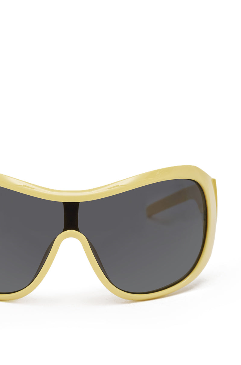 Close-up of BUTTA SUNGLASSES—yellow shield frames with dark tinted lenses—an oversized streetwear style, displayed against a plain white background. 3
