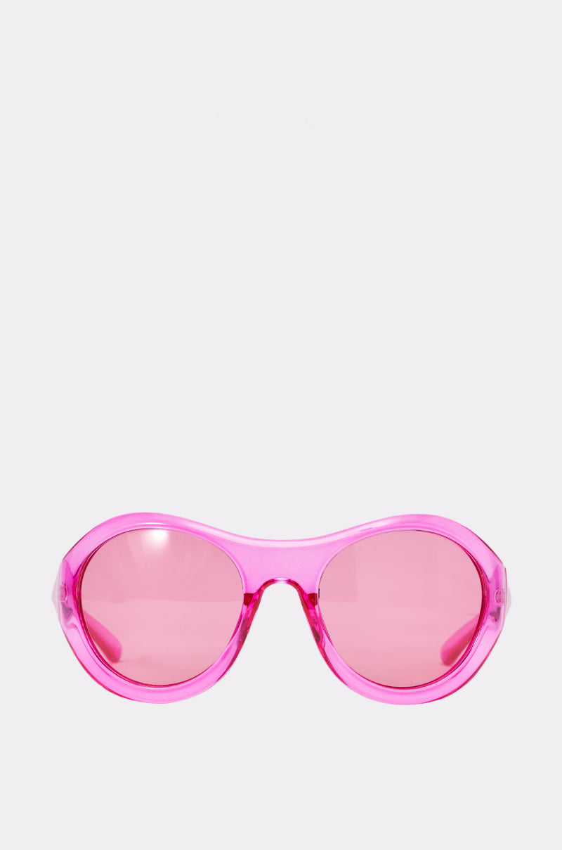 The ITS MY WORLD SUNGLASSES feature oversized retro frames and matching neon pink lenses, displayed against a plain light background. These playful sunglasses add a vibrant, bold statement to any outfit. 0