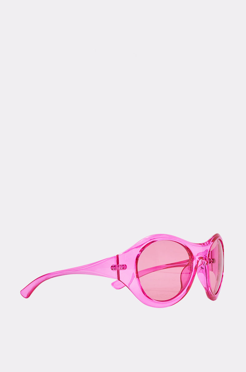 The ITS MY WORLD SUNGLASSES showcase oversized oval frames and pink-tinted lenses in a retro style, displayed from a side view against a plain light background—perfect for summer flair. 3