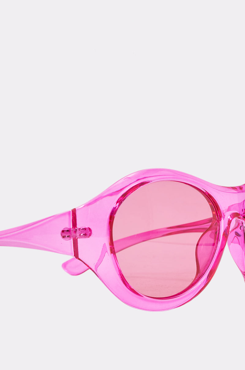 Close-up of ITS MY WORLD SUNGLASSES, showcasing oversized round frames with matching pink-tinted lenses against a plain light background. 4